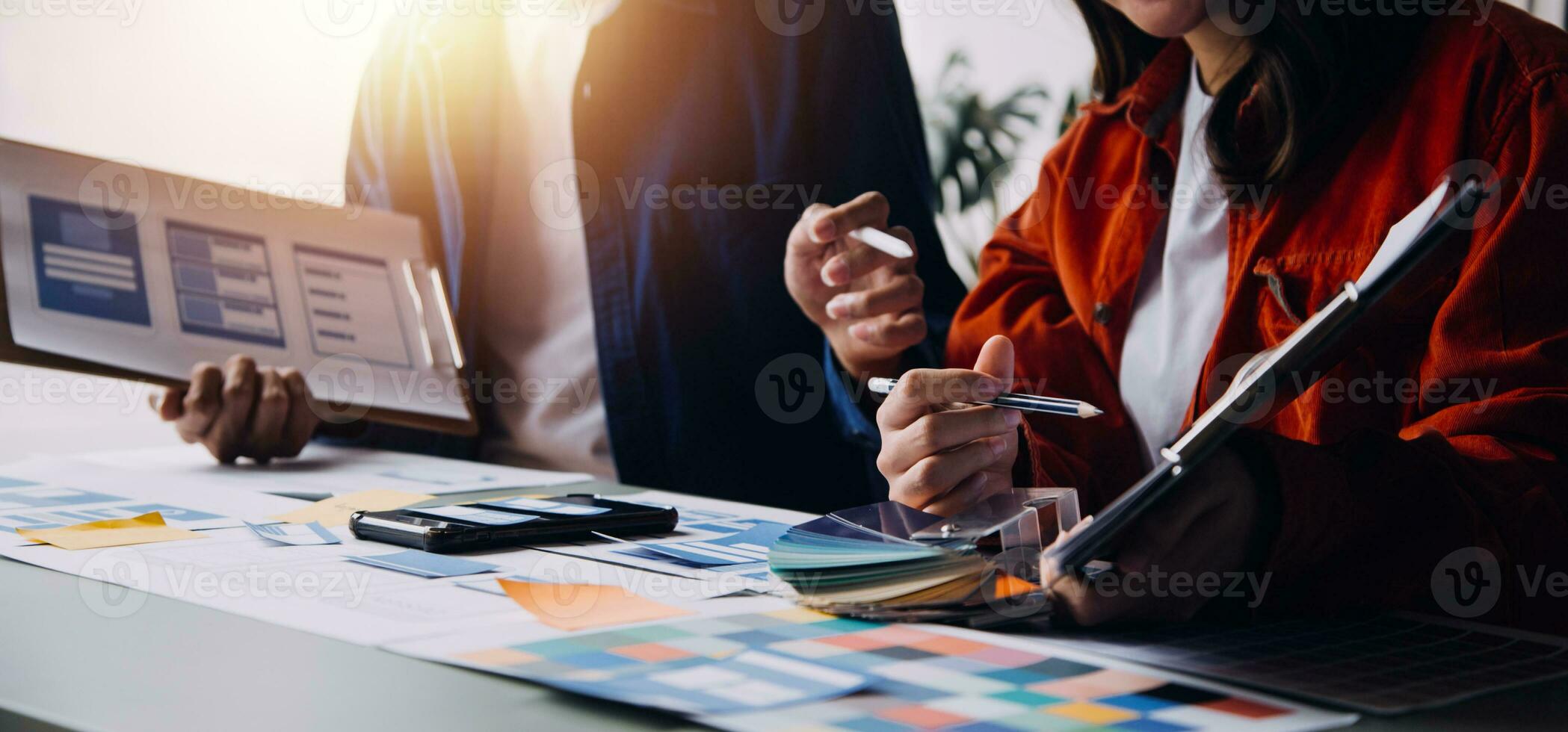 Close up ux developer and ui designer brainstorming about mobile app interface wireframe design on table with customer breif and color code at modern office.Creative digital development agency photo
