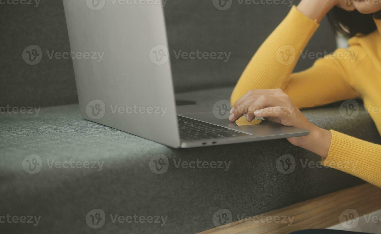 Young adult happy smiling Hispanic Asian student wearing headphones talking on online chat meeting using laptop in university campus or at virtual office. College female student learning remotely. photo