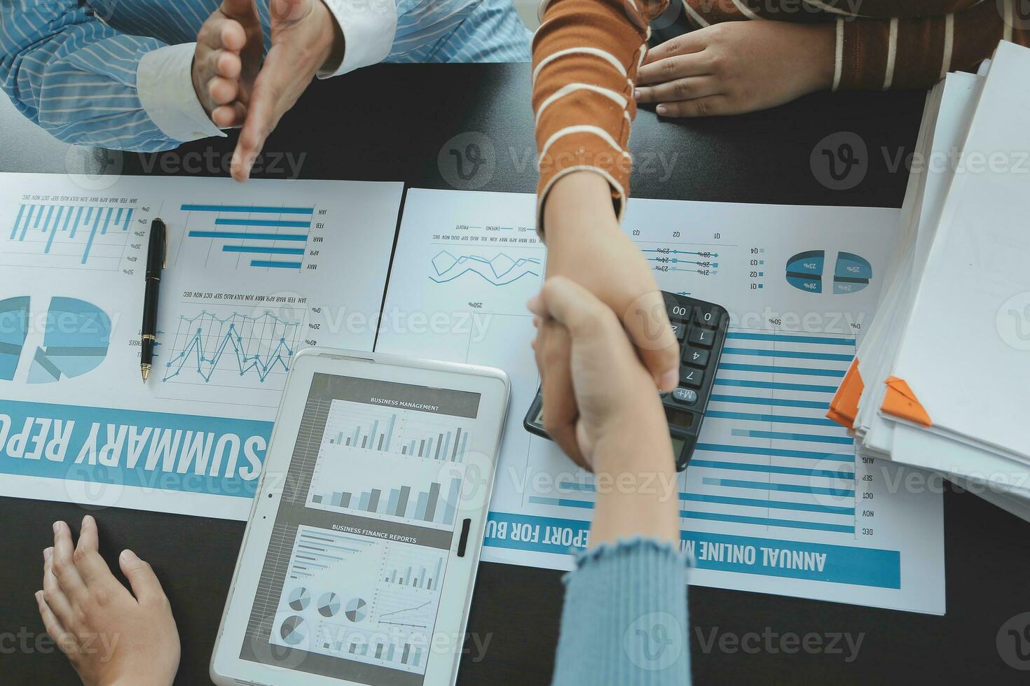 Financial analysts analyze business financial reports on a digital tablet planning investment project during a discussion at a meeting of corporate showing the results of their successful teamwork. photo