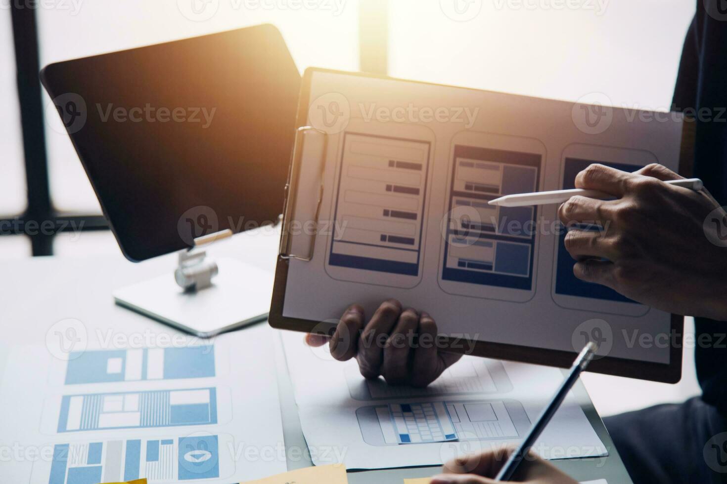 Close up ux developer and ui designer brainstorming about mobile app interface wireframe design on table with customer breif and color code at modern office.Creative digital development agency photo