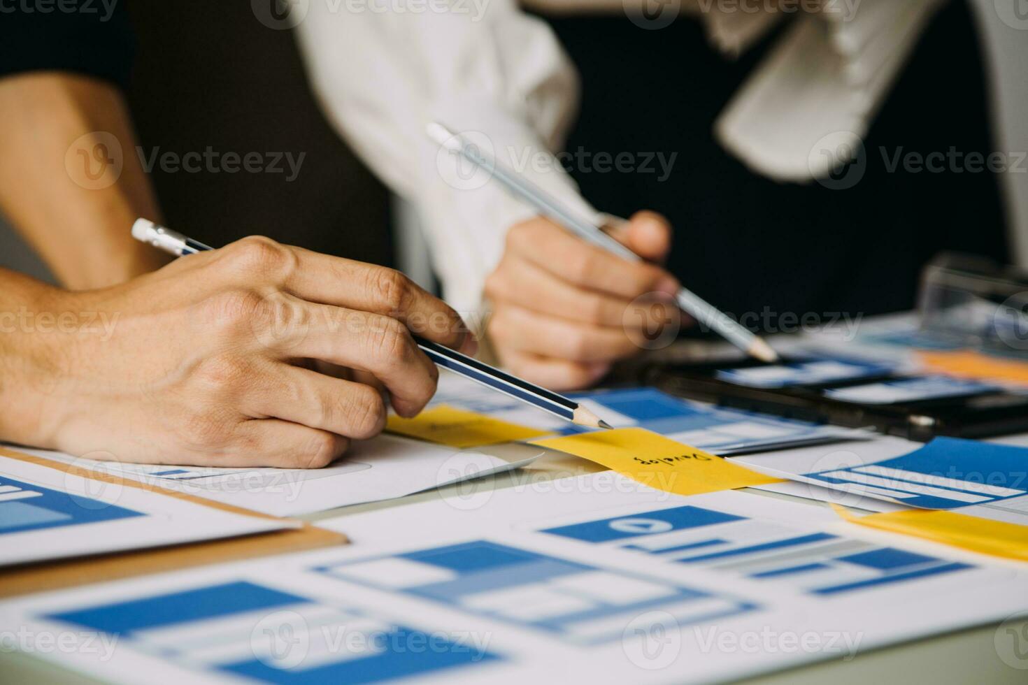 Close up ux developer and ui designer brainstorming about mobile app interface wireframe design on table with customer breif and color code at modern office.Creative digital development agency photo