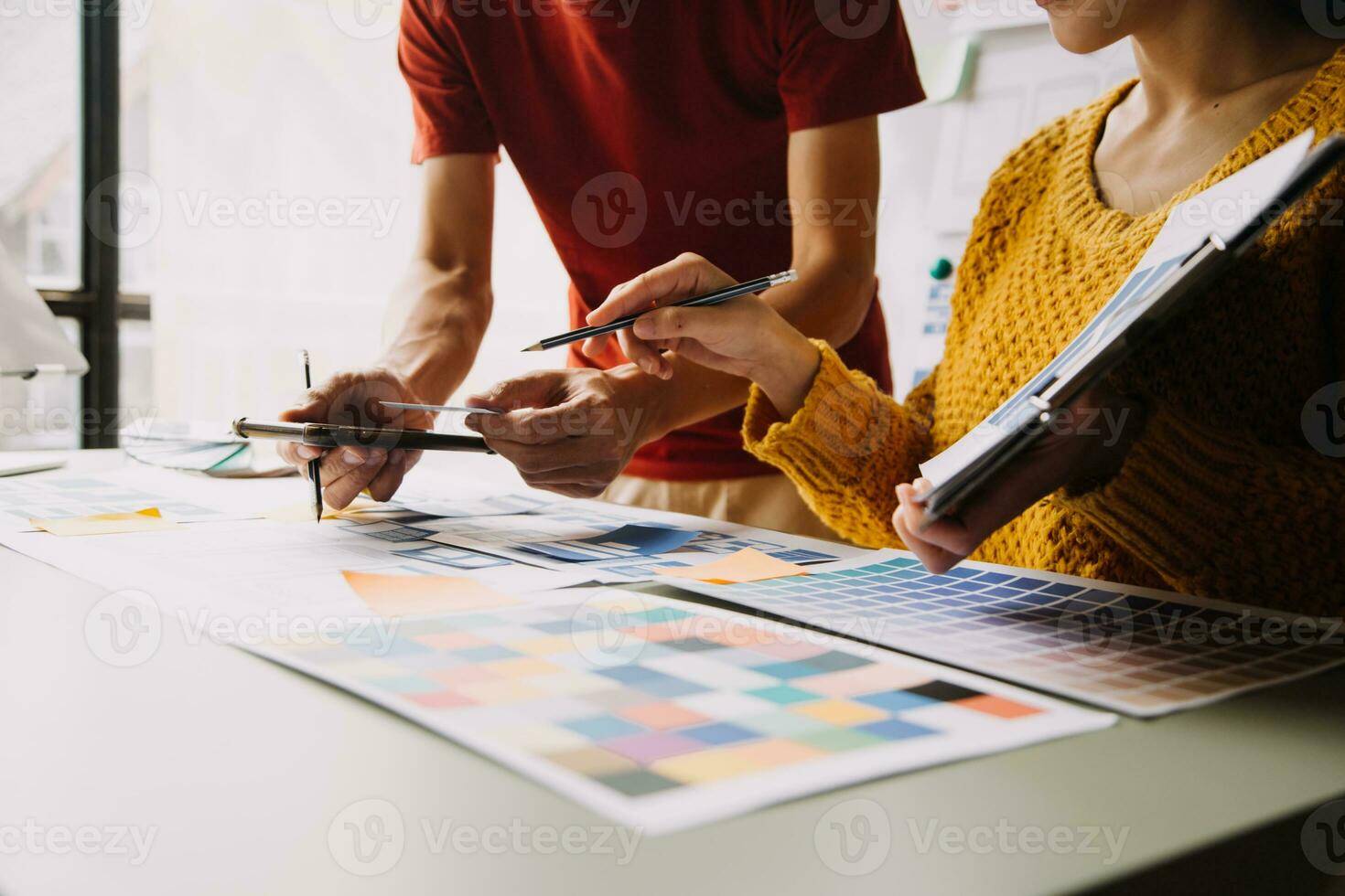 Close up ux developer and ui designer brainstorming about mobile app interface wireframe design on table with customer breif and color code at modern office.Creative digital development agency photo