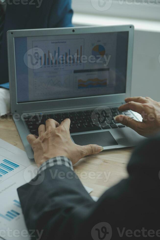 Group of confident business people point to graphs and charts to analyze market data, balance sheet, account, net profit to plan new sales strategies to increase production capacity. photo