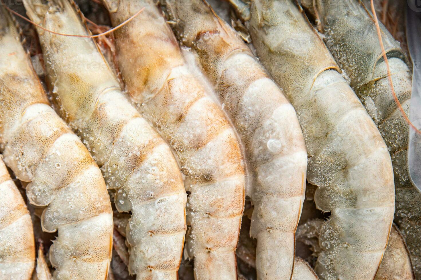 gambas raw frozen in ice big shrimp seafood prawn meal food snack pescatarian diet on the table copy space food background rustic top view keto or paleo photo