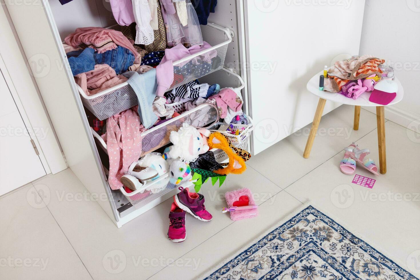 pink things lie in disarray in a white closet. Mess, girl's room photo