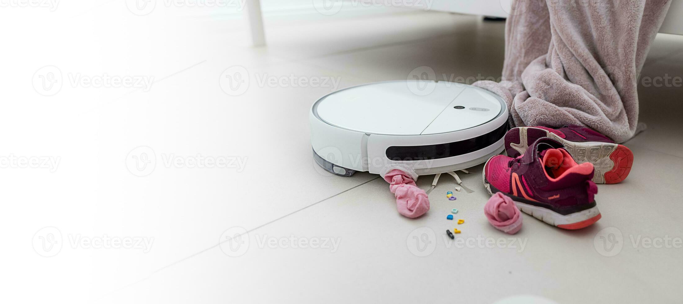 Cleaning with a robotic vacuum cleaner at home. Mess in the girl's room. copy paste space photo