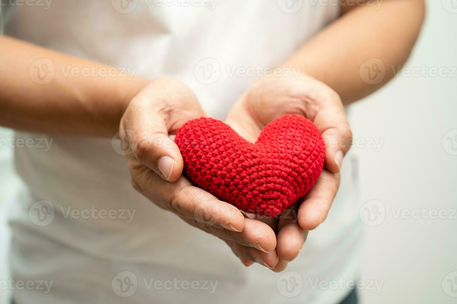 asiático mujer voluntario participación un rojo corazón, donación, caridad, confianza, seguro concepto. foto