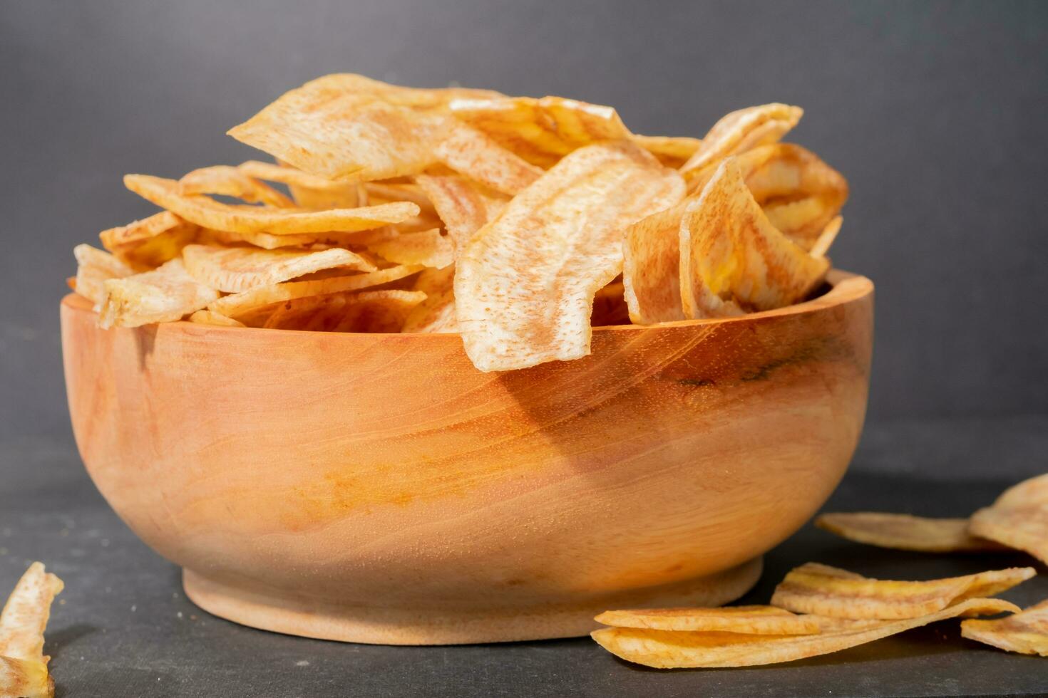 Banana chips with a sweet and salty taste made from fried raw bananas in a wooden bowl. Traditional snacks photo