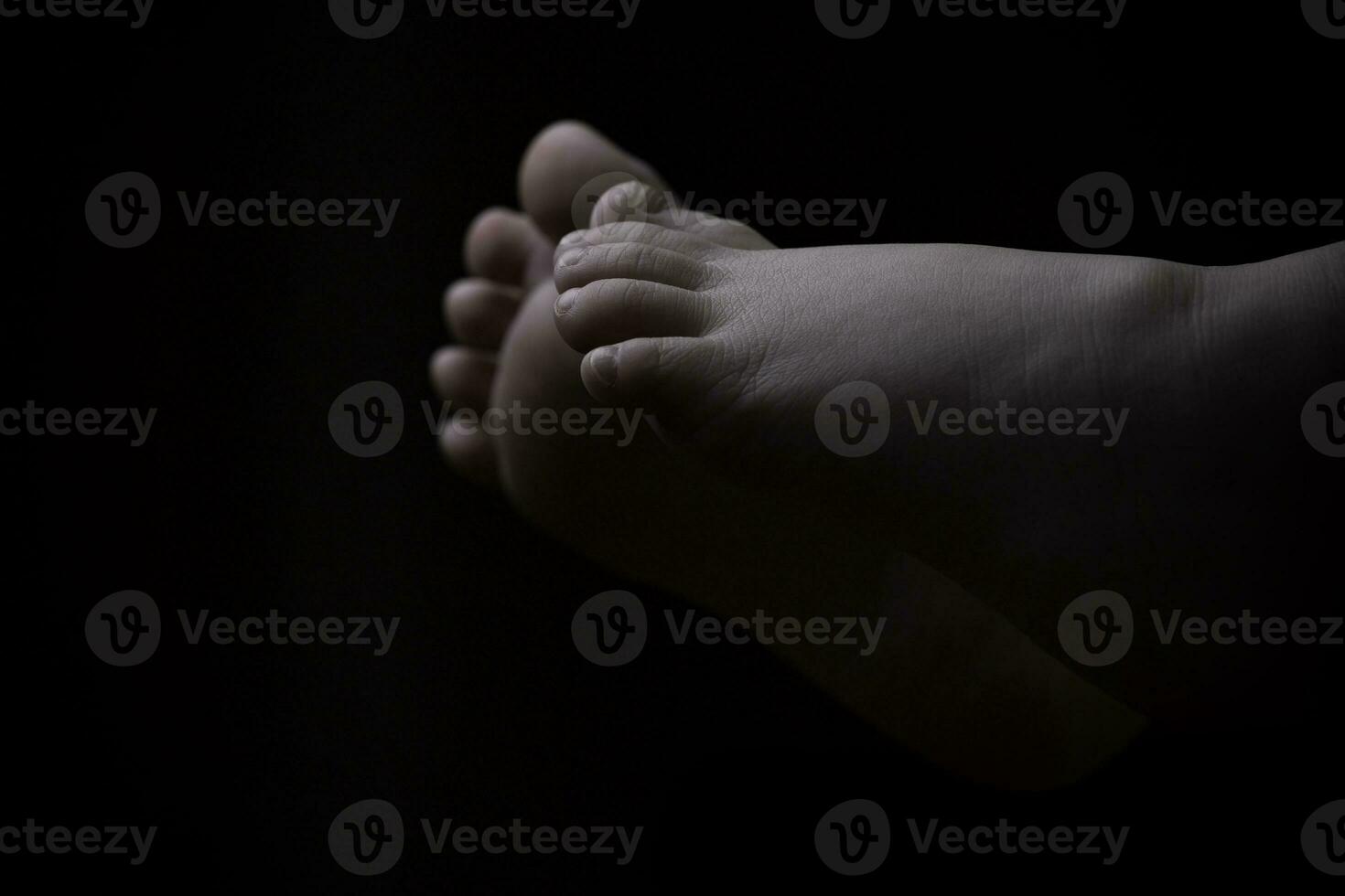 Beautiful baby girl lying down with feet up black and white photo