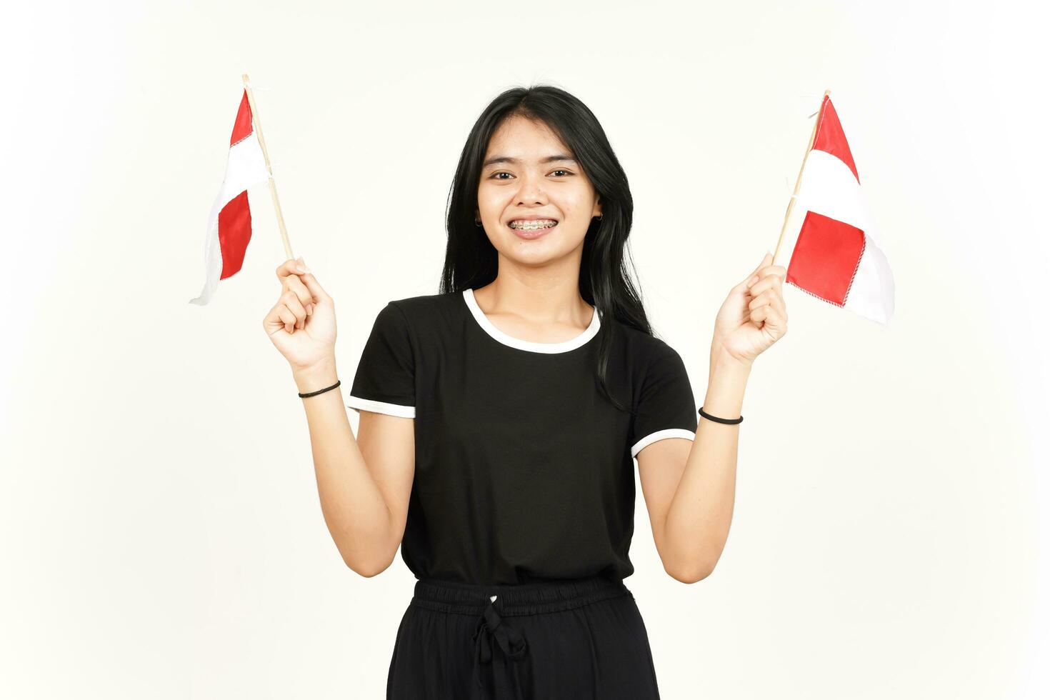 sonriendo y sosteniendo la bandera indonesia de una hermosa mujer asiática aislada de fondo blanco foto