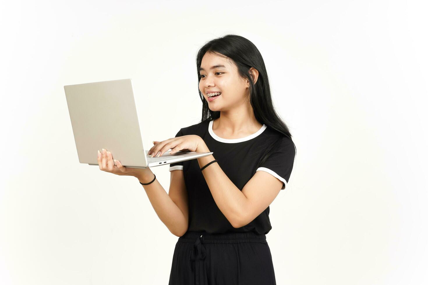 sonriente y utilizando ordenador portátil de hermosa asiático mujer aislado en blanco antecedentes foto