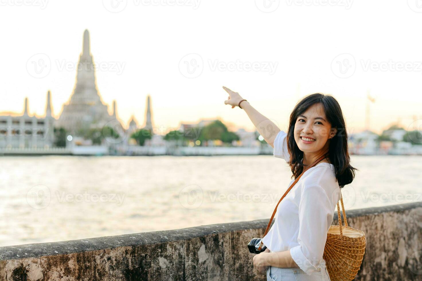 Portrait young beautiful asian woman smiling while travel at Wat Arun sunset view point, Bangkok, Thailand. photo