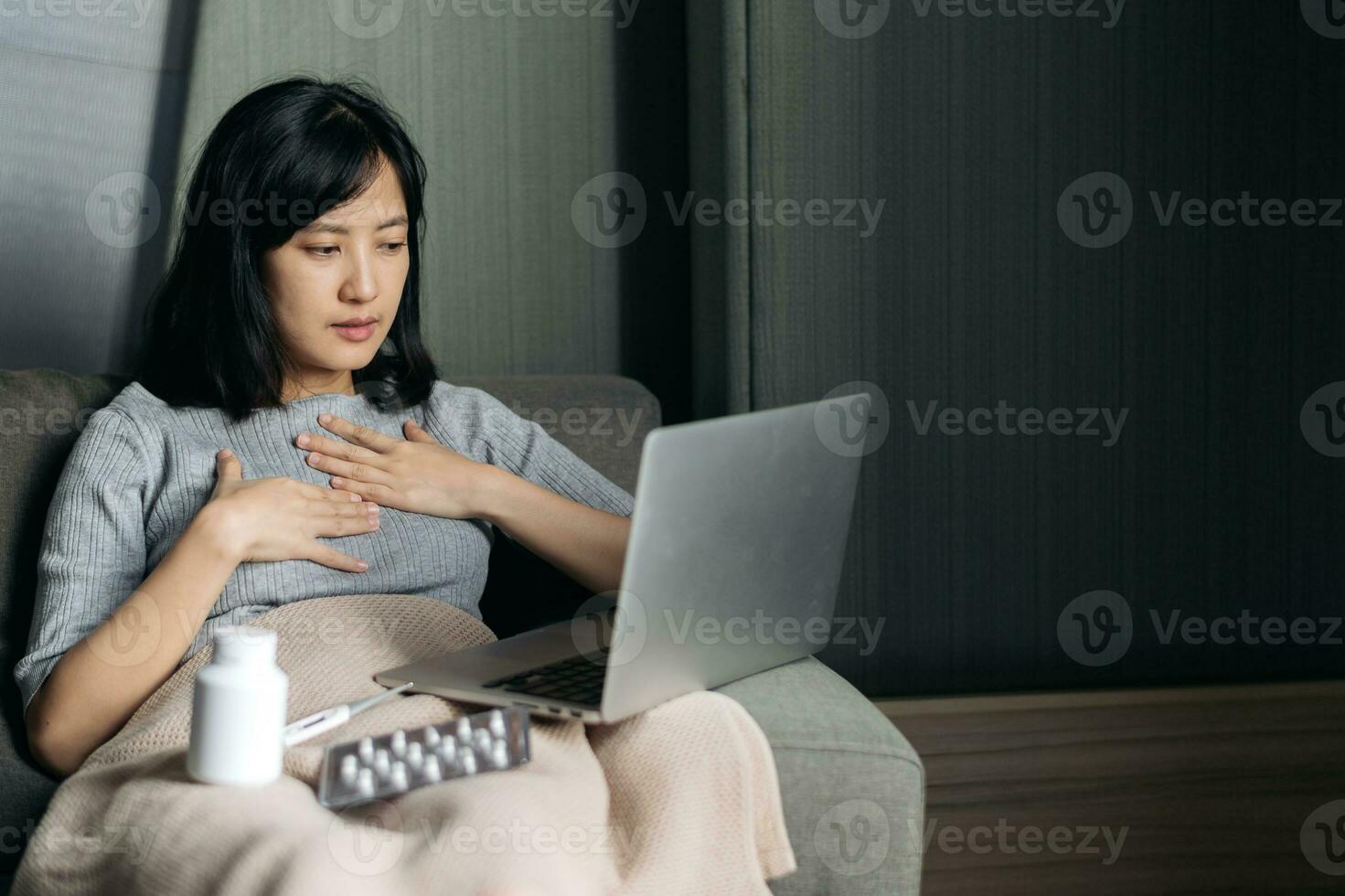 Sick asian woman with medicine having video call conference medical app in telehealth on laptop. Healthcare, technology and people concept photo