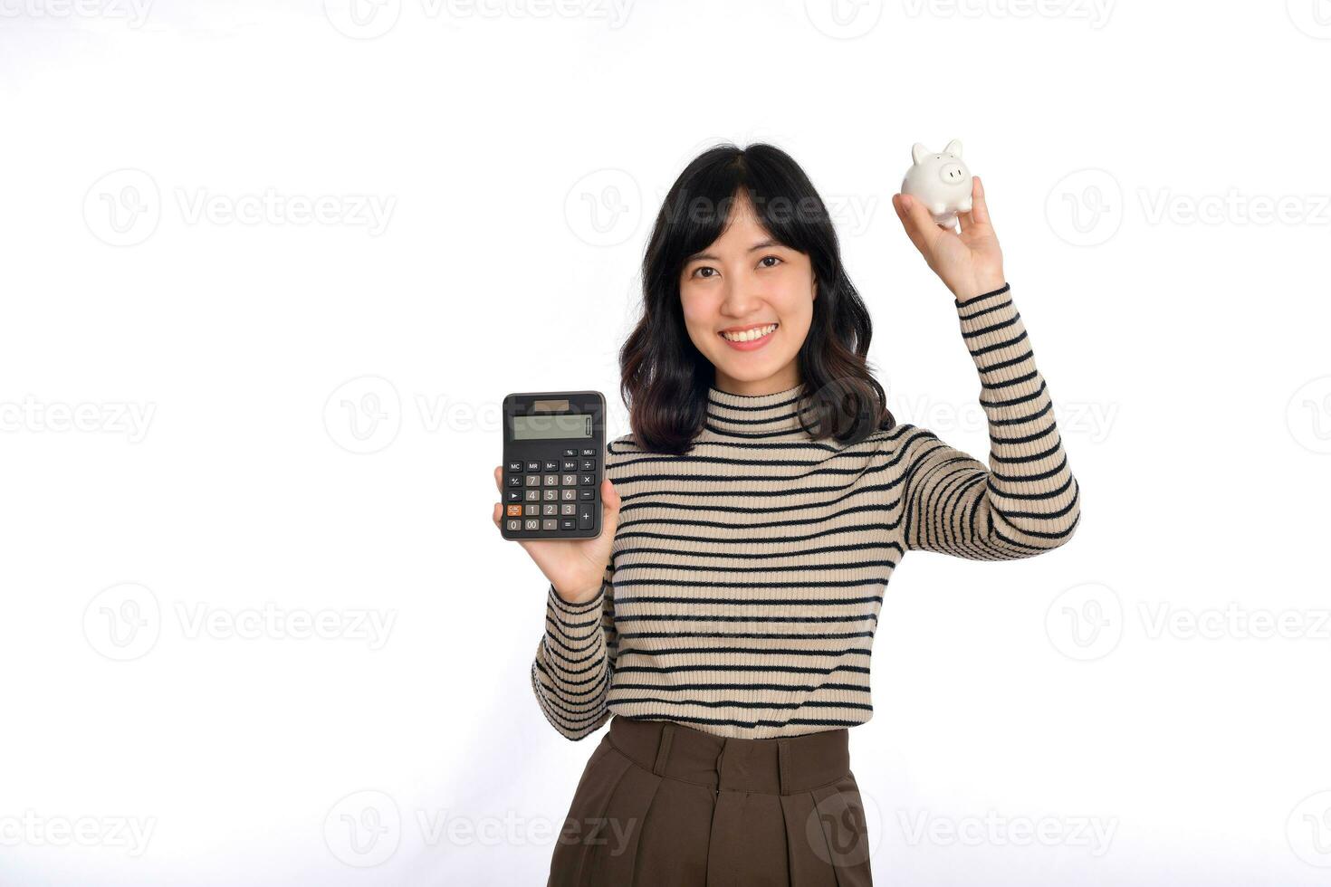 Portrait of young Asian woman casual uniform holding white piggy bank and calculator isolated on white background, Financial and bank saving money concept photo