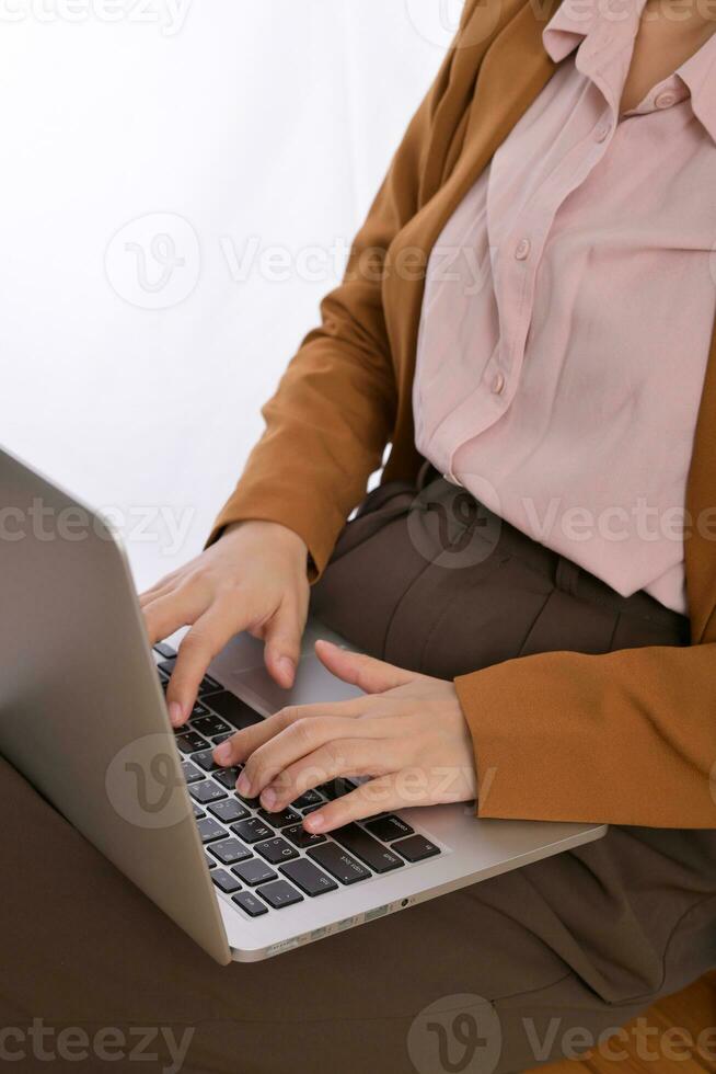 Close up of a business woman using laptop on her lap while sitting photo
