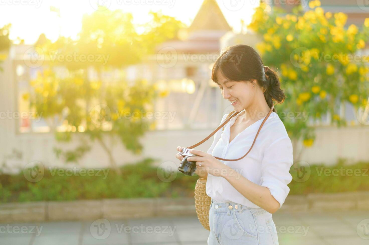 Portrait of asian woman traveler using camera at street of Bangkok, Thailand. Asia summer tourism vacation concept photo