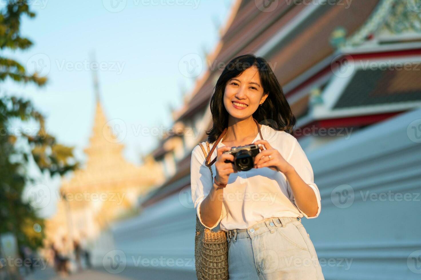 retrato de asiático mujer viajero utilizando cámara a calle de bangkok, tailandia Asia verano turismo vacaciones concepto foto