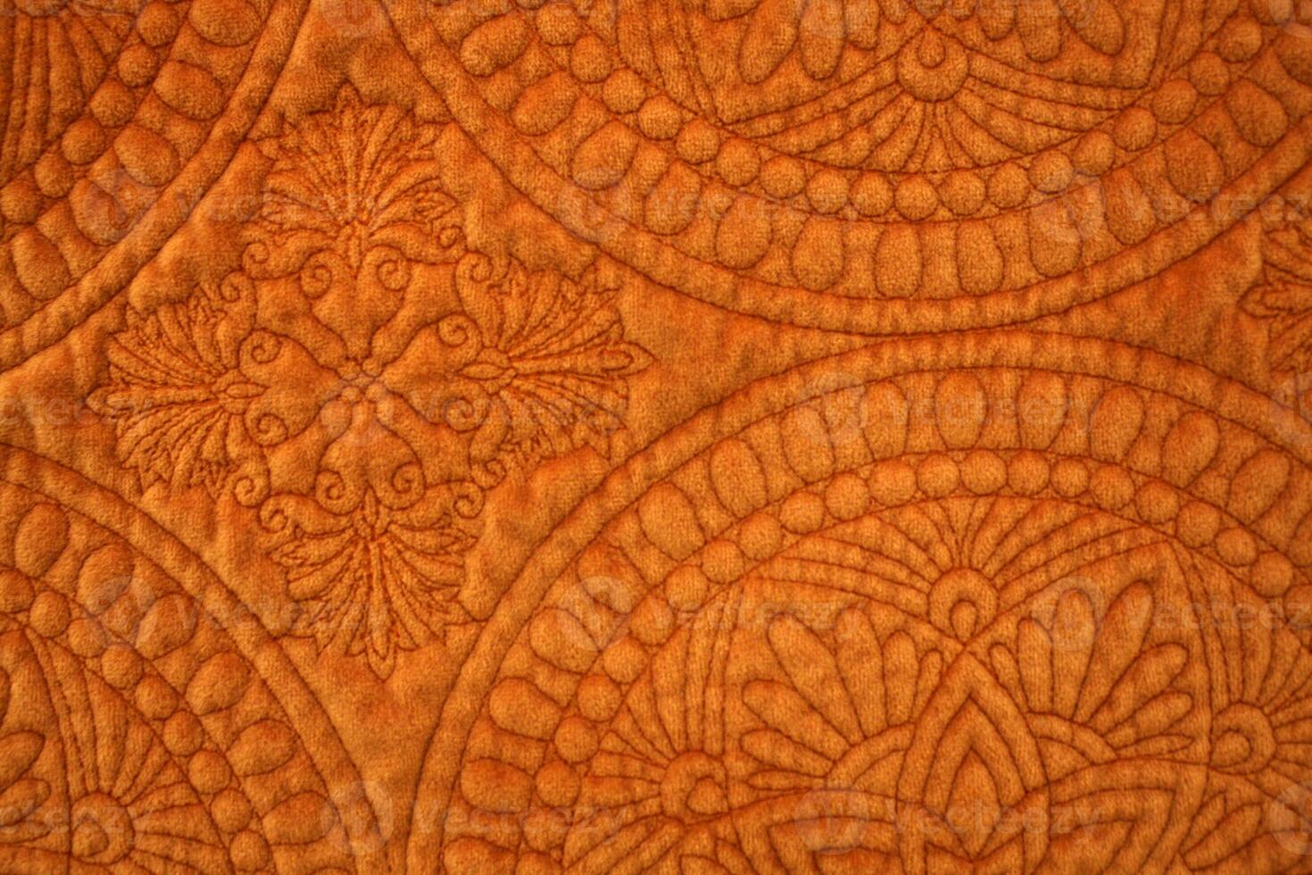 Close Up of Orange Colored Quilted Fabric photo