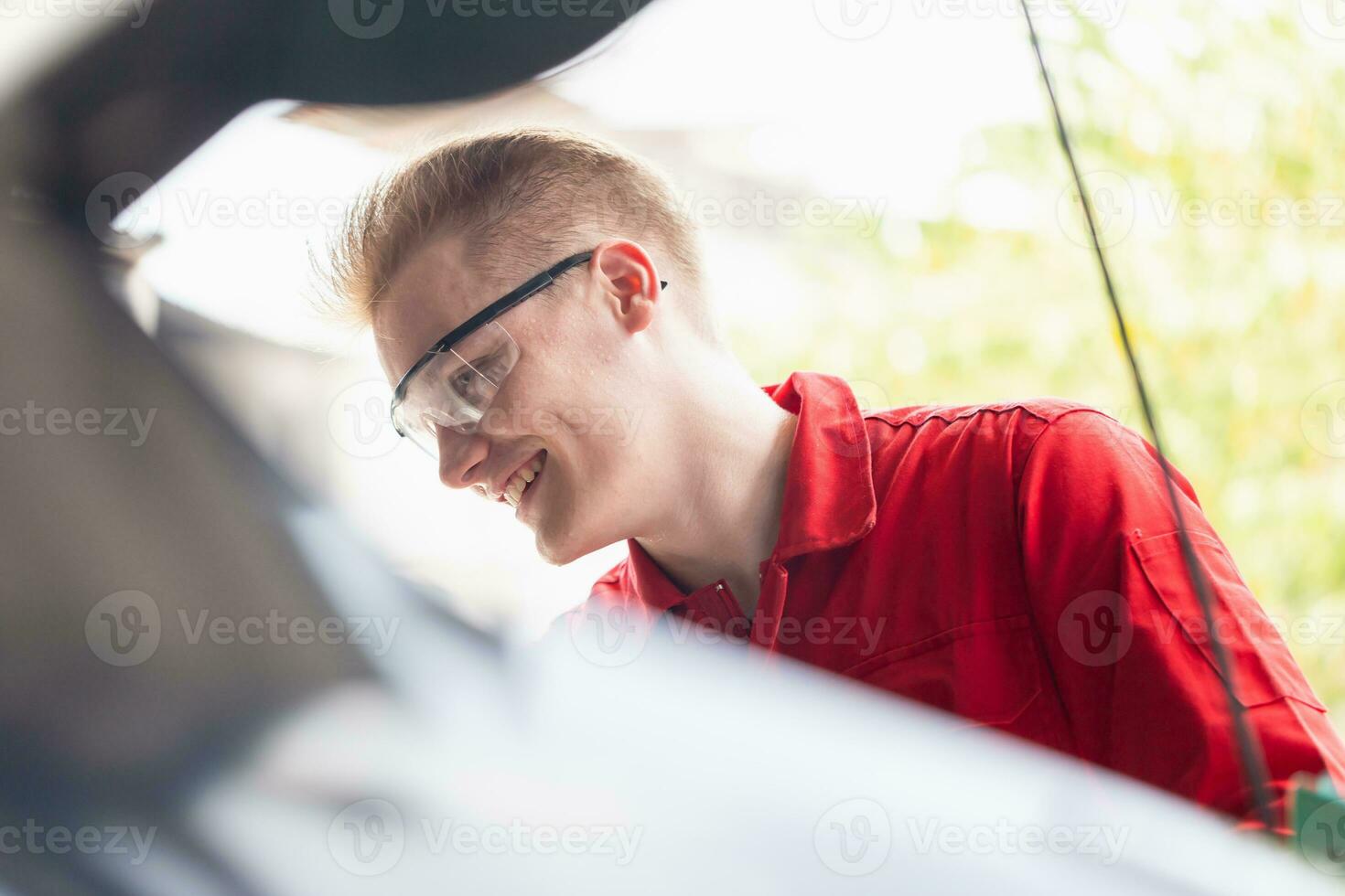 Cheerful car mechanic in repair garage, Technician man working in auto repair shop, Car repair and maintenance concepts photo