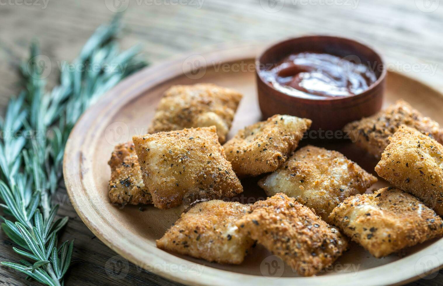 Plate with fried ravioli on the wooden board photo