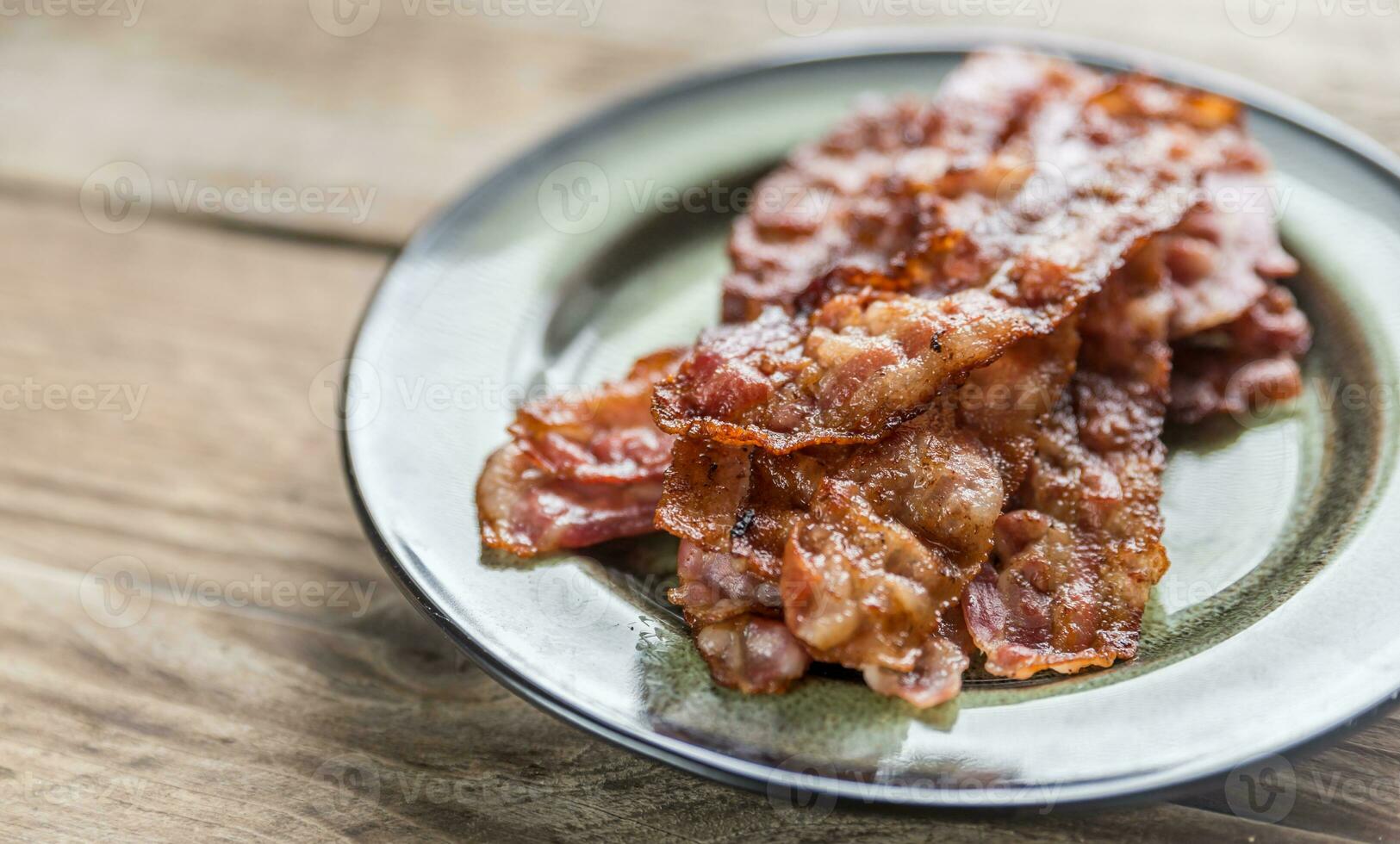 apilar de frito tocino tiras en el plato foto