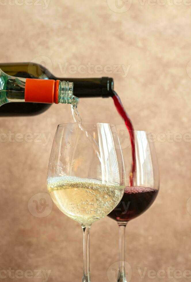 White and red wine pouring into glasses photo