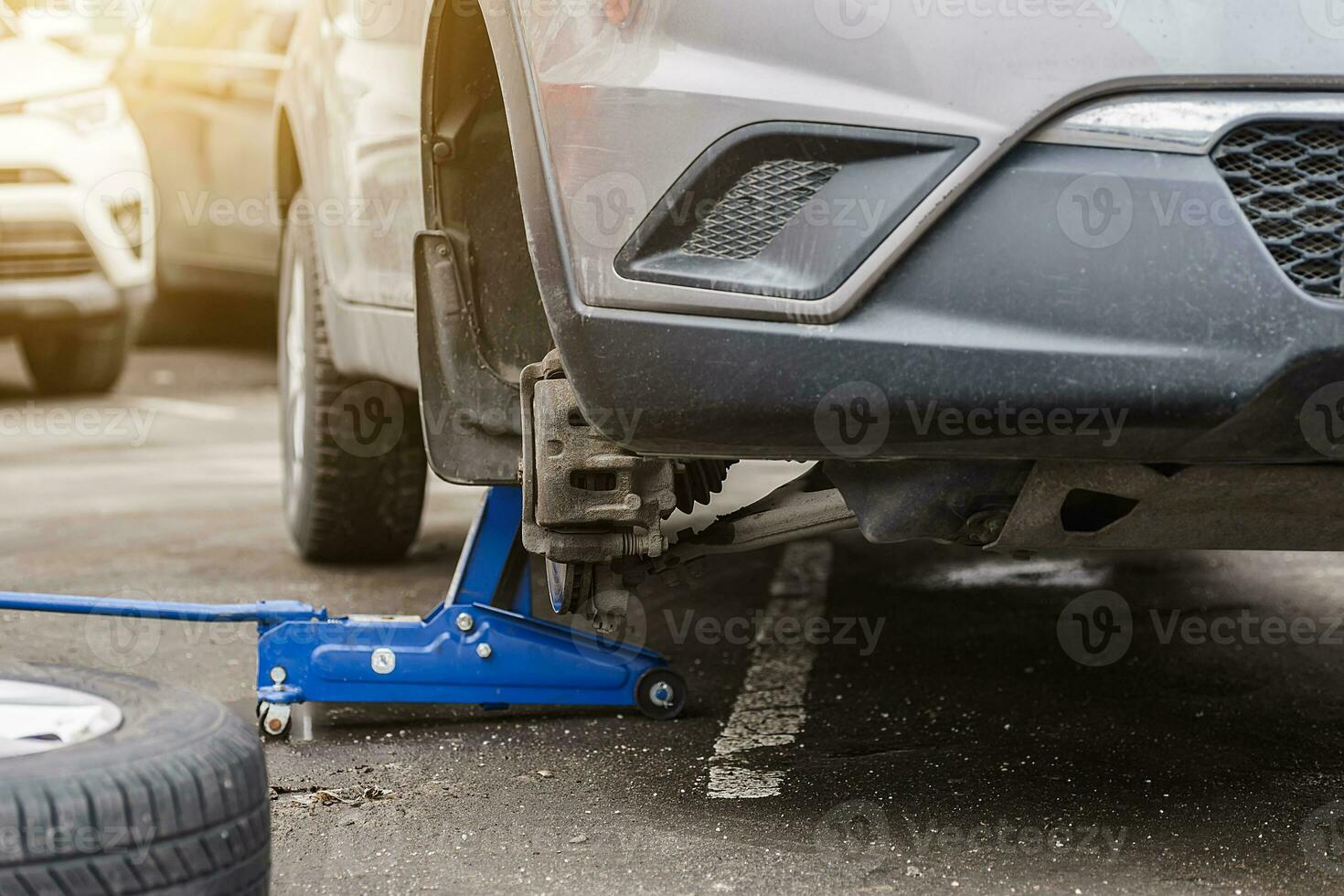 Car wheel replacement. Self-service tire fitting concept. Using a wheel wrench to twist the wheel nuts. photo