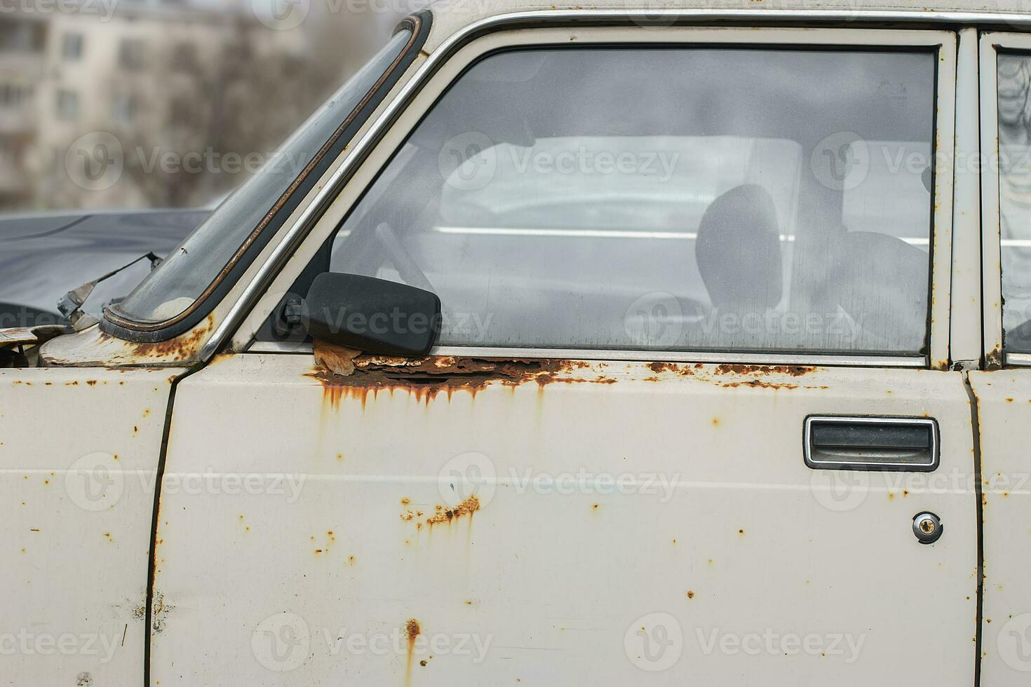 Old rusty and dusty car parked in the street. photo