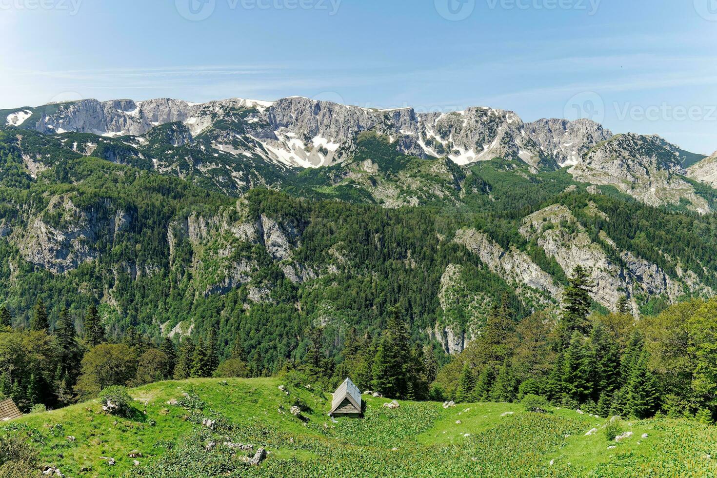 View of different mountain peaks in the spring still with snow. Cottage with a beautiful view. Amazing scenic viewpoint. Hiking lifestyle. Adventurous life. Travel the world. photo