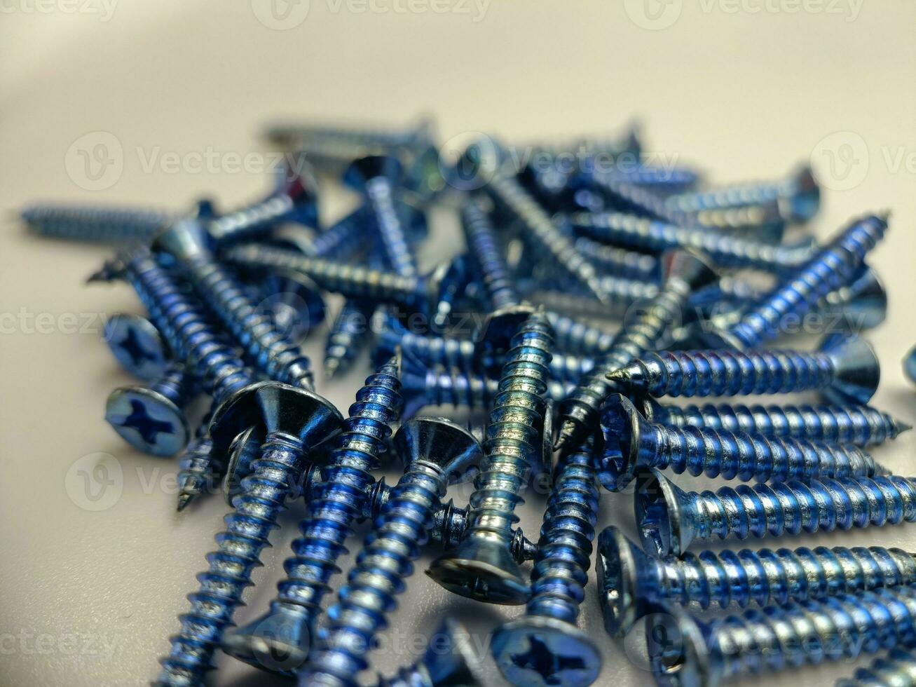 Tapping screws made of steel on Gray background, metal screw, iron screw, chrome screw, screws as a background, wood screw, concept industry. photo