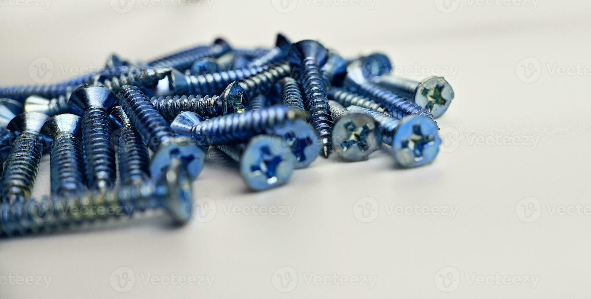 Tapping screws made of steel on Gray background, metal screw, iron screw, chrome screw, screws as a background, wood screw, concept industry. photo