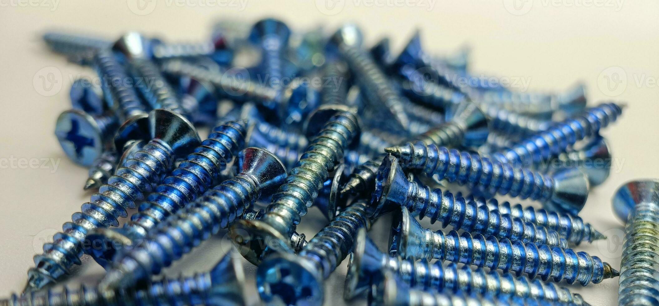 Tapping screws made of steel on Gray background, metal screw, iron screw, chrome screw, screws as a background, wood screw, concept industry. photo