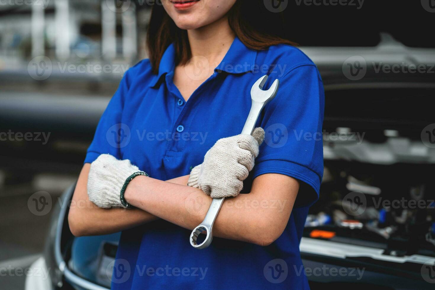 mecánico femenino que trabaja en un garaje mecánico de automóviles. una mecánica femenina repara el automóvil de un cliente en un centro de servicio de automóviles. inspección del coche. taller de reparación de automóviles. concepto de servicio concepto de servicio de reparación de automóviles. foto