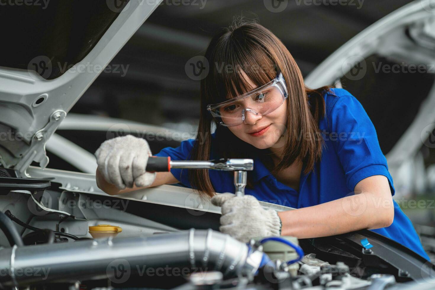 profesional Servicio concepto. profesional asiático hembra mecánico comprobación y reparando coche capó en garaje a garaje coche mecánico coche mantenimiento concepto foto