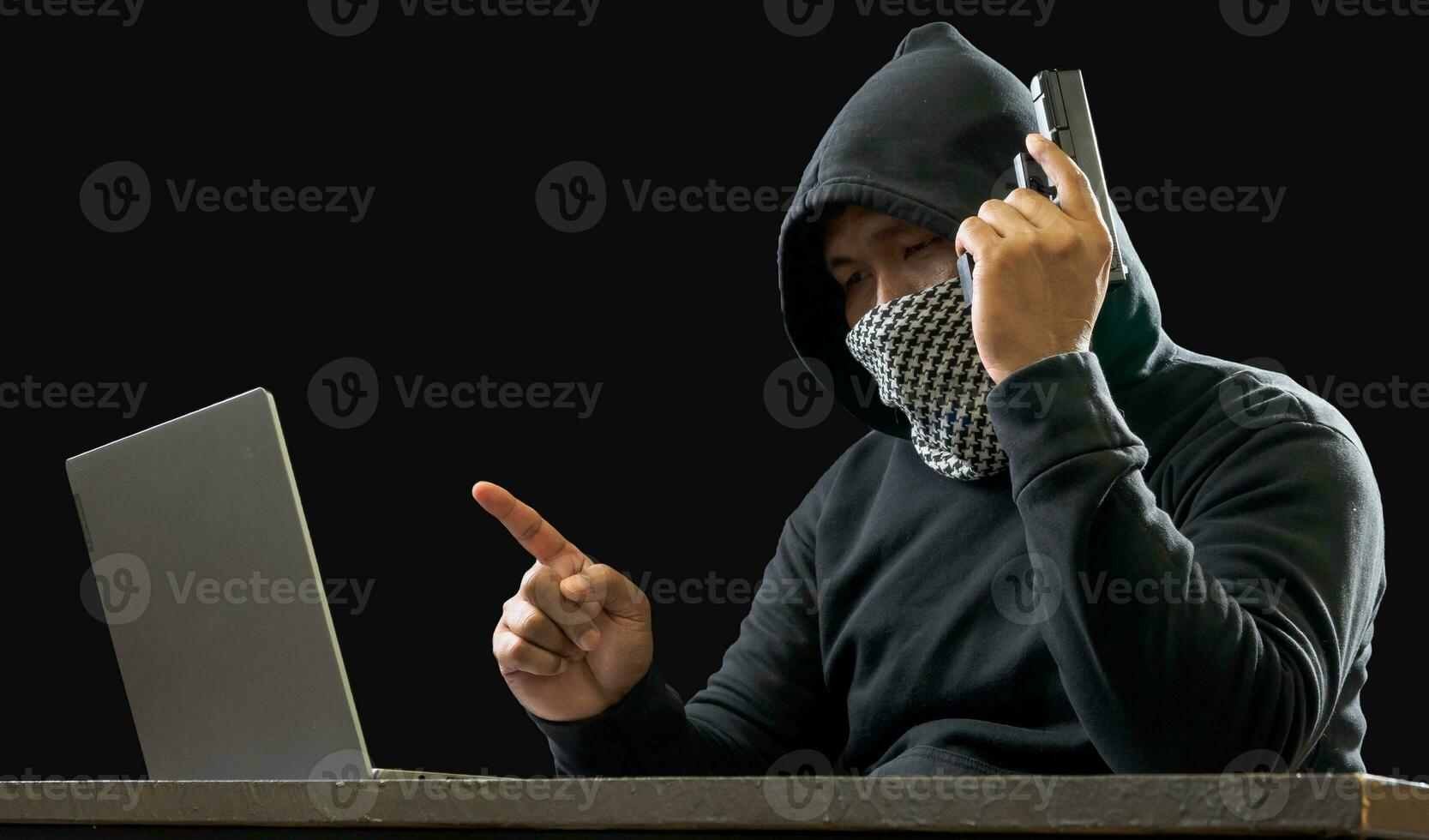 Hacker spy man one person in black hoodie sitting on a table looking computer laptop used login password attack security to circulate data digital in internet network system, night dark background. photo