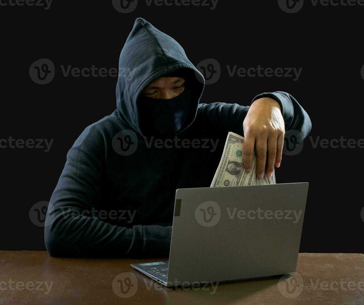 Hacker spy man one person in black hoodie sitting on a table looking computer laptop used login password attack security to circulate data digital in internet network system, night dark background. photo