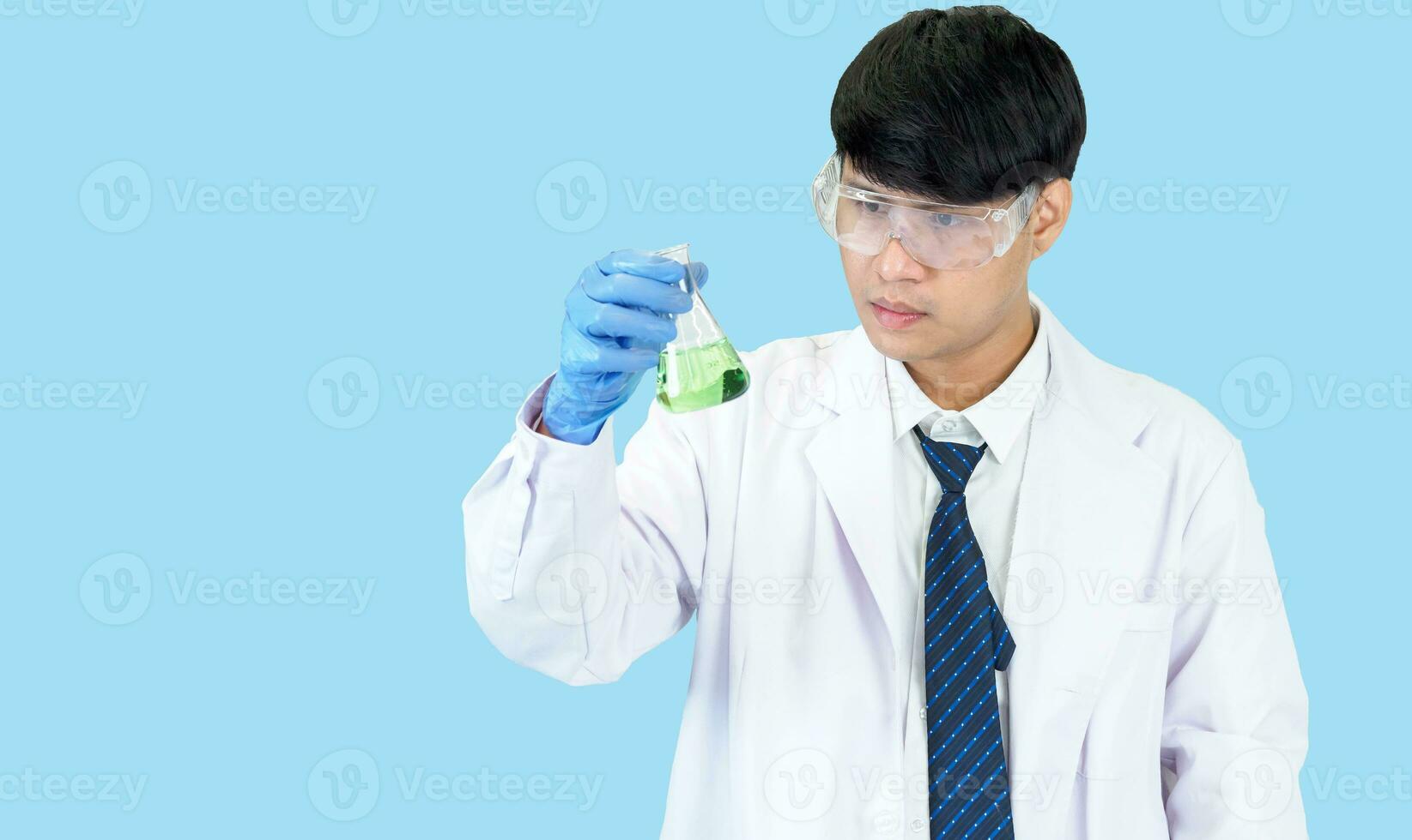 Asian man student scientist or doctor one person, wearing a white gown, standing, looking and smiling, blue background with a stethoscope auscultating the heart around his neck. photo