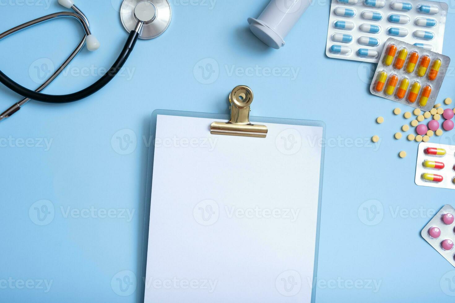 Blank tablet mockup with colorful pills and stethoscope. Healthcare and medicine concept flat lay photo