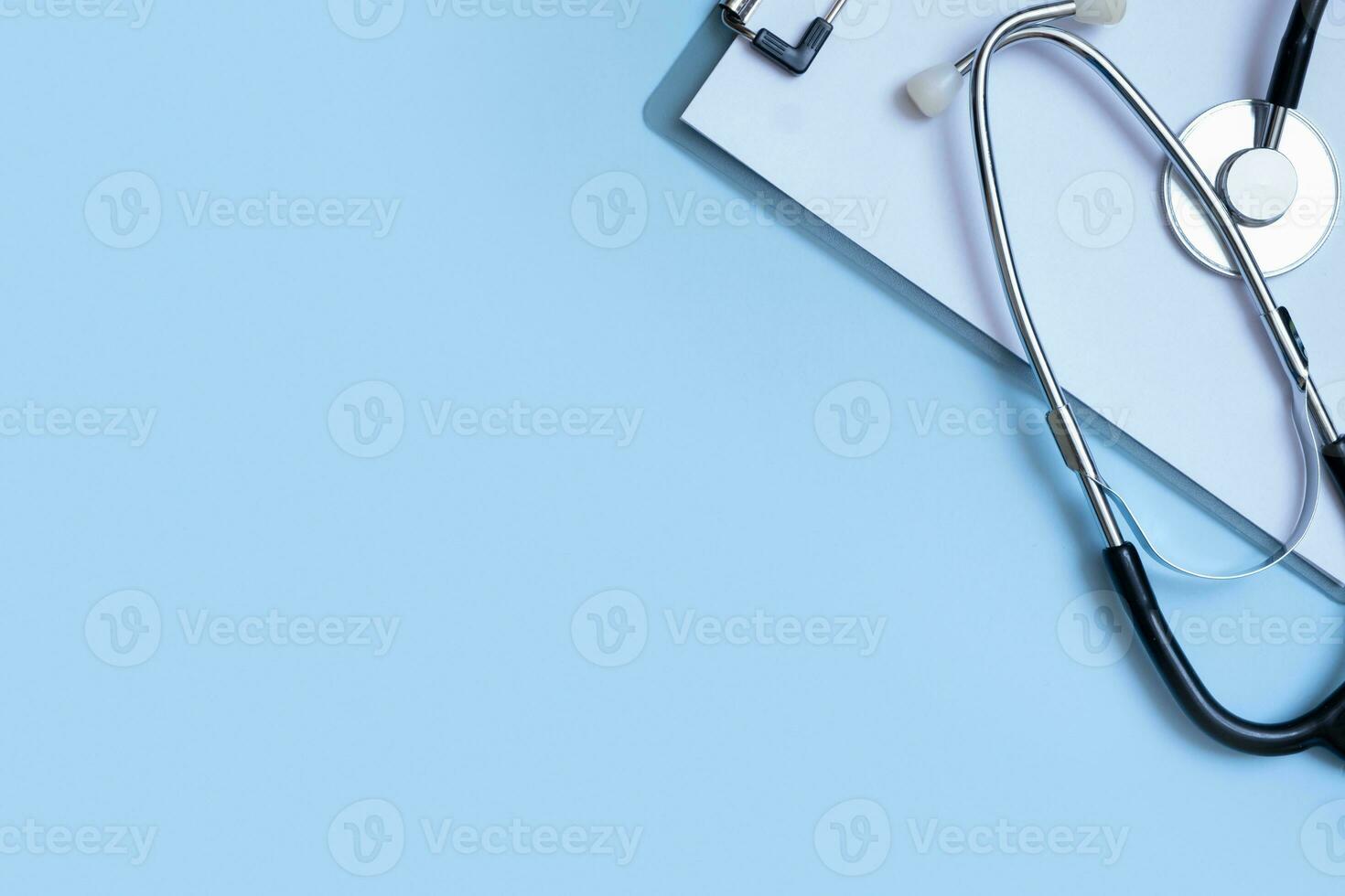 Fragment of stethoscope, tablet on blue background with copy space. Healthcare and medicine concept flat lay, top view photo