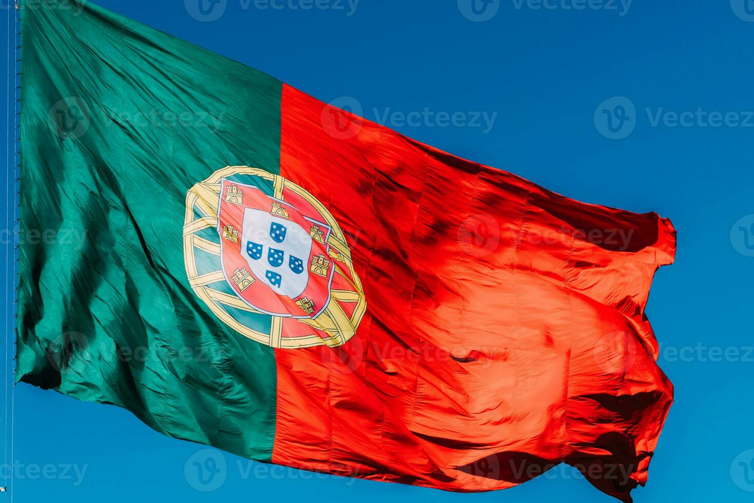Portugal flag isolated on the blue sky waving in the wind photo