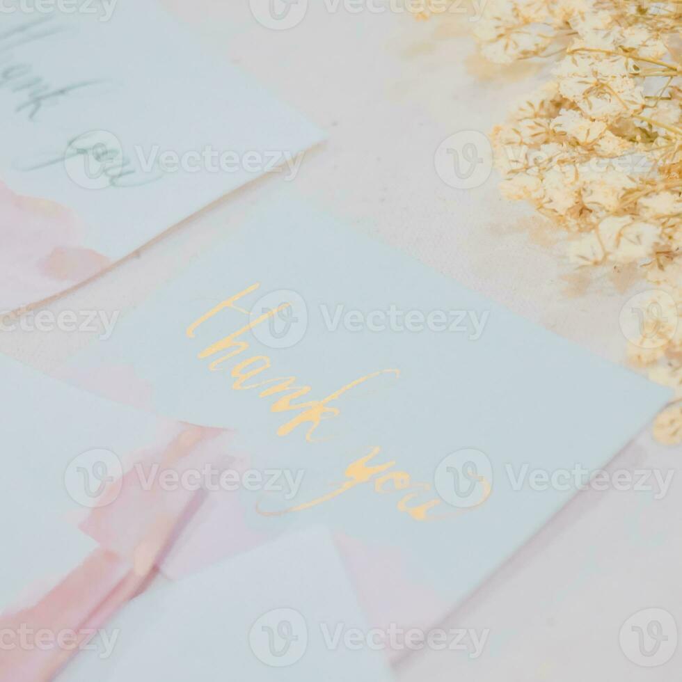 A white card with gold lettering that says thank you on it. photo