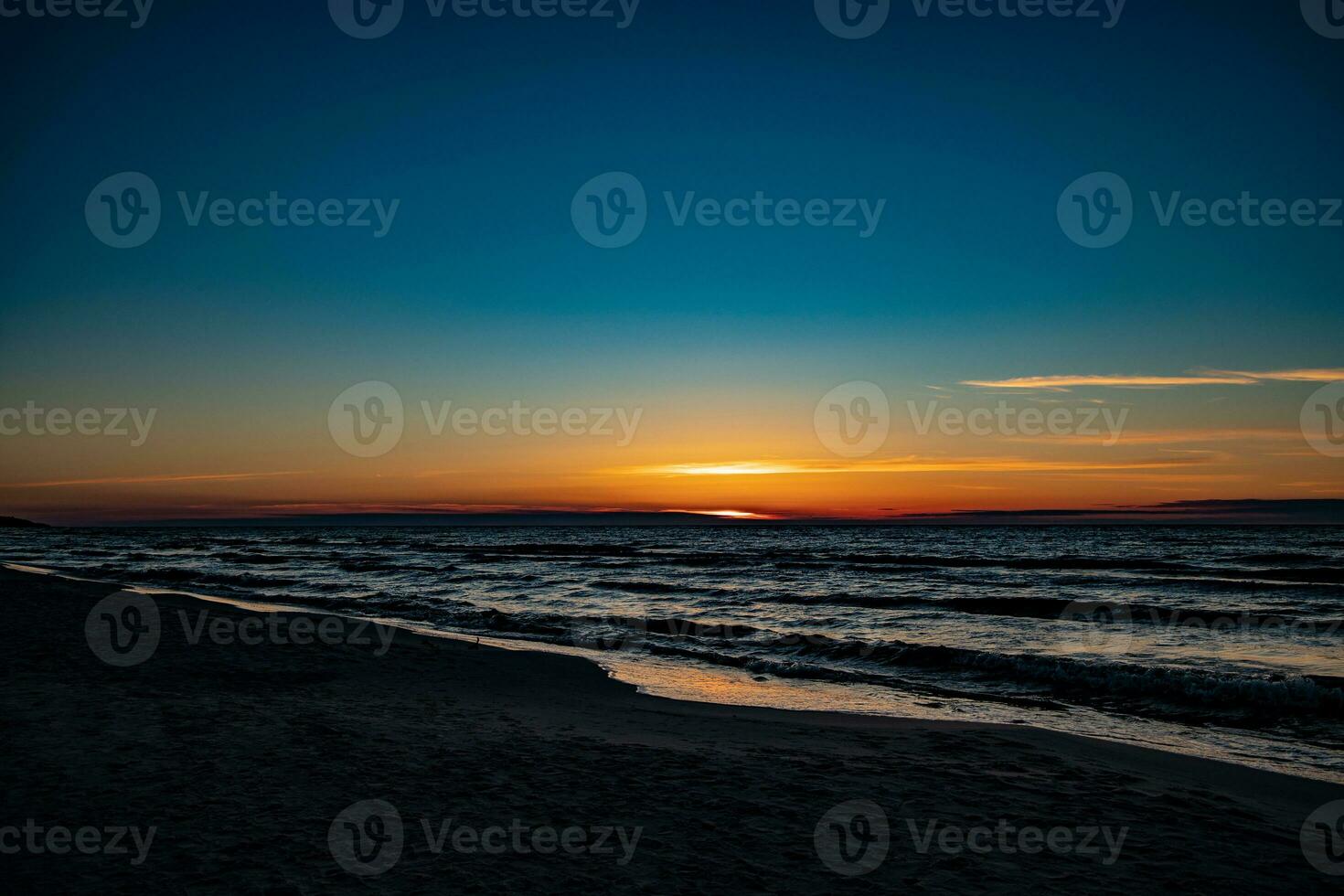 pintoresco calma puesta de sol con vistoso nubes en el costas de el báltico mar en Polonia foto