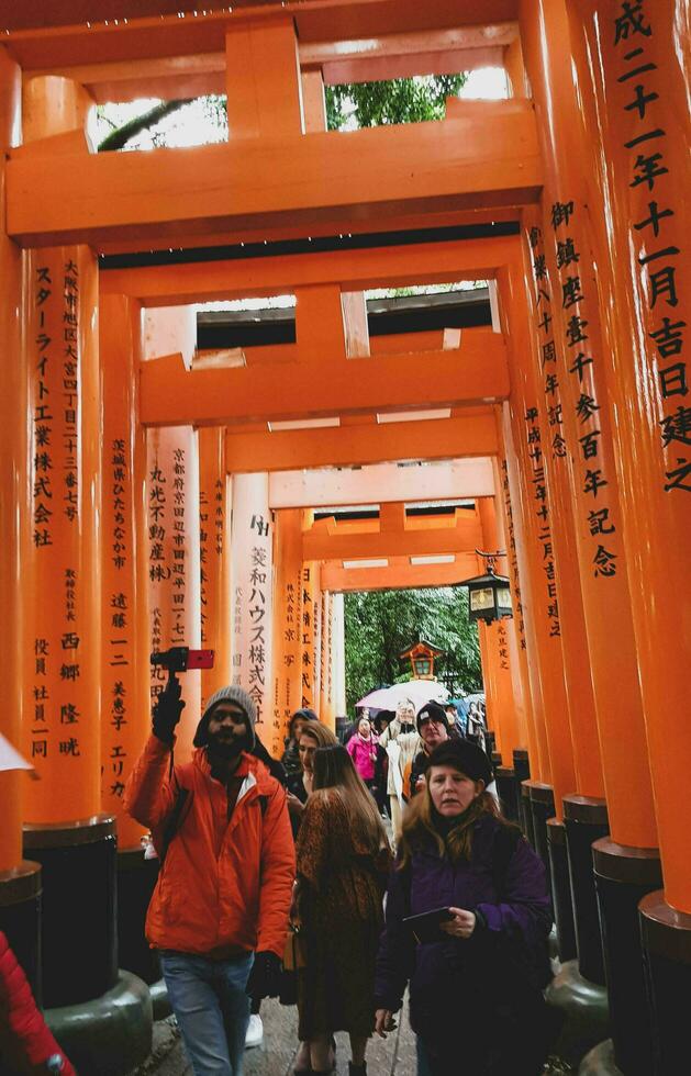 Kyoto, Japan in April 2019. Tourists taking pictures and walking in the Fushimi Inari area of Kyoto. photo