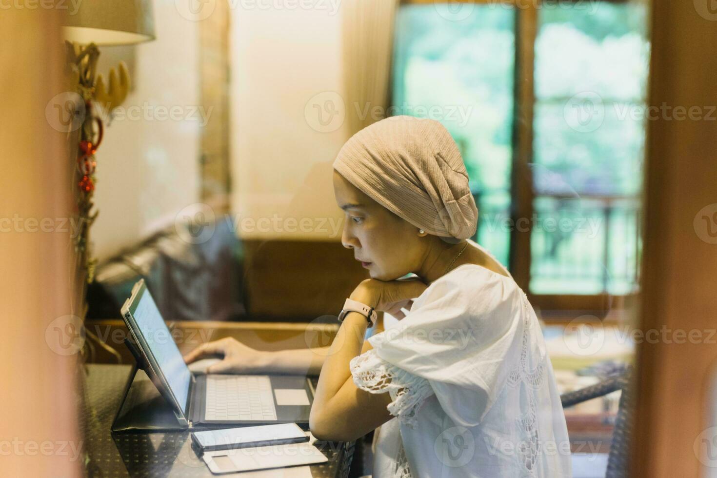 Serious successful woman working on laptop at home. photo