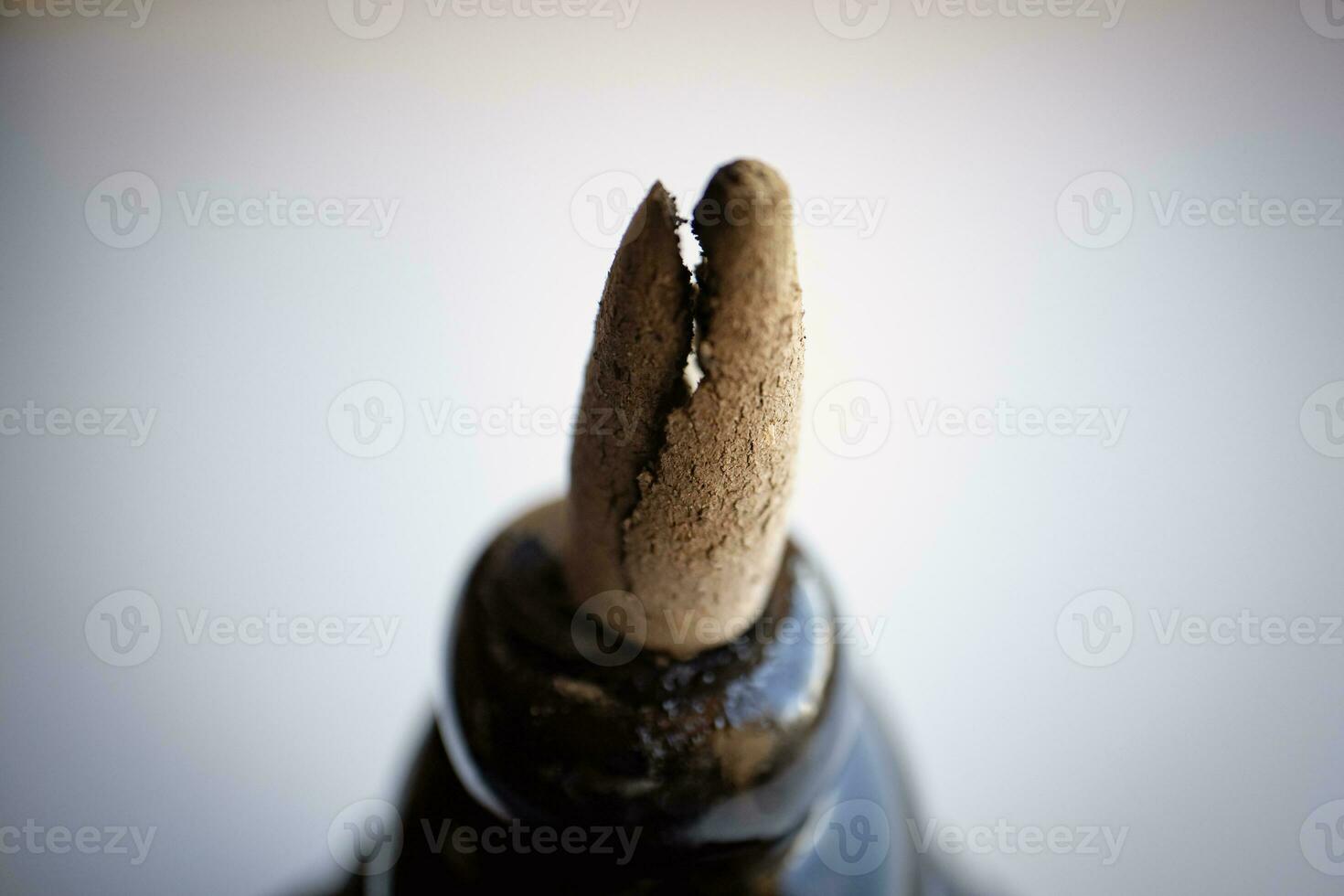 Burnt pyramid incense cracked on top of incense holder macro with visible lines in ashes photo