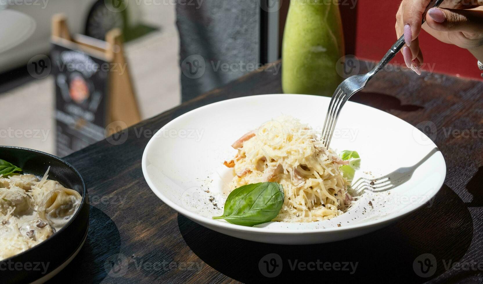 mujer comiendo italiano pasta sentado a el café mostrador mirando a el ventana, teniendo almuerzo foto