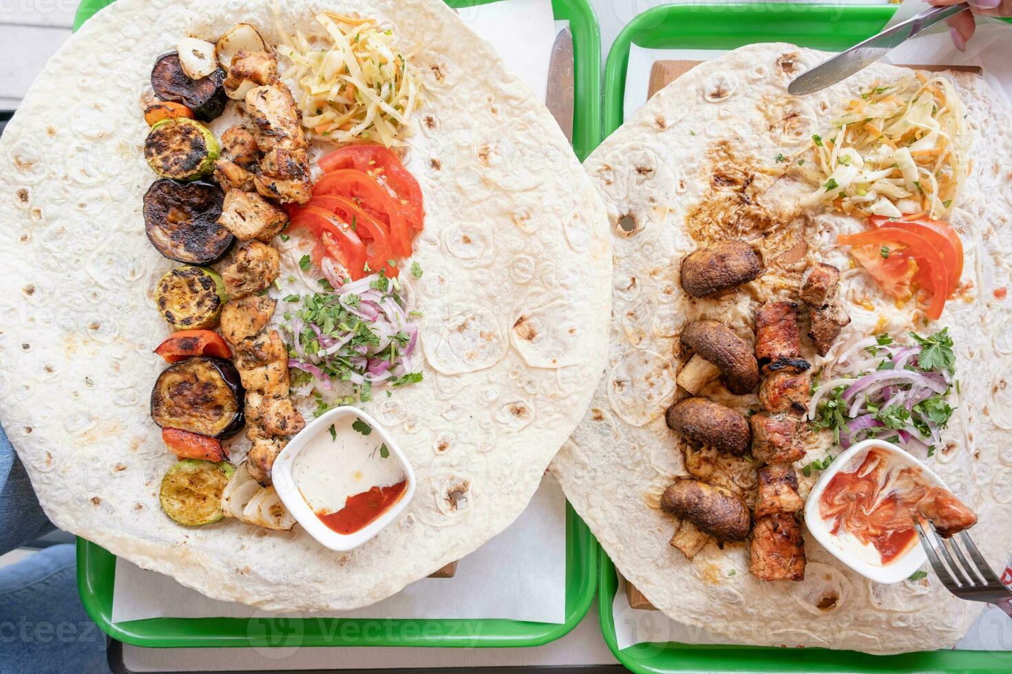 Grilled kebab with pita bread and vegetables on tray in summer fast food street cafe, top view photo