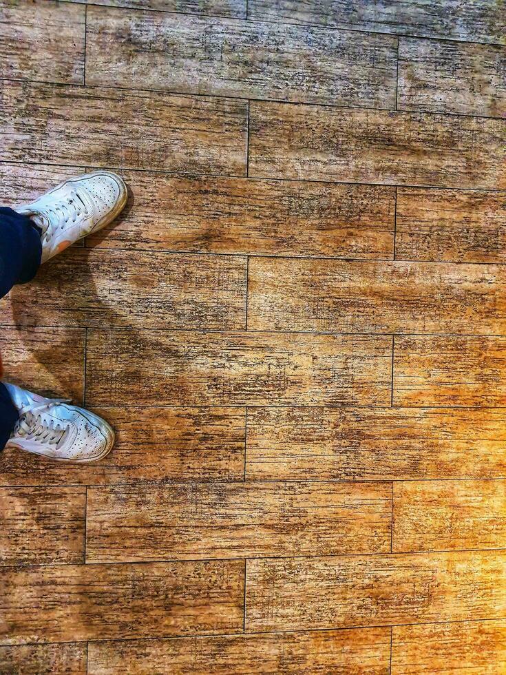 A pair of white shoes on a floor with a wooden texture. photo