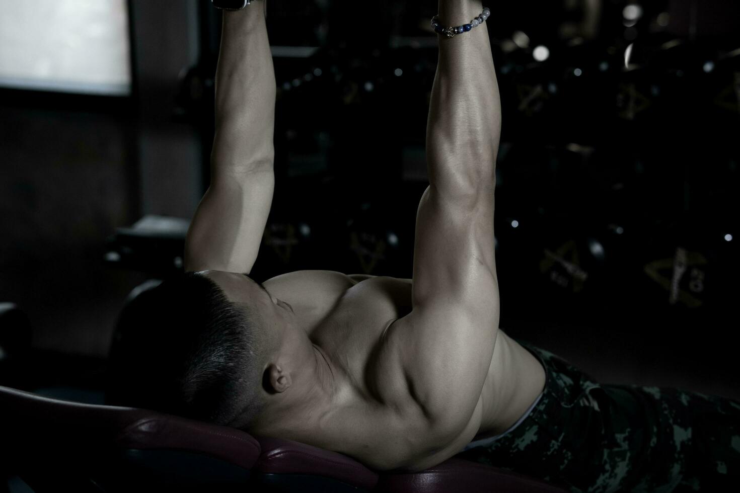 Sexy body of muscular young soldier Asian man in gym. Concept of health care, exercise fitness, Strong muscle mass, body enhancement, fat reduction for men's health supplement product presentation. photo