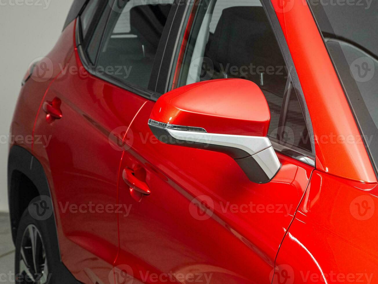 Side mirror of a  red car close up. Exterior detail photo